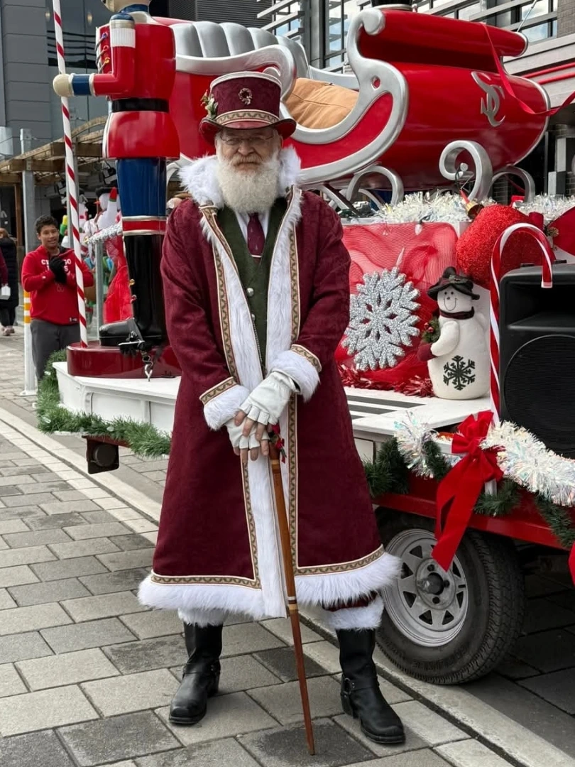 Saint Rick standing in front of a holiday parade float